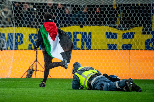 Security personel chase a pitch invader