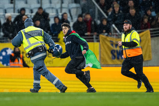 Security personell chase a pitch invader