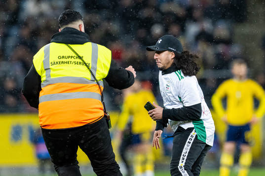 Security personell chase a pitch invader