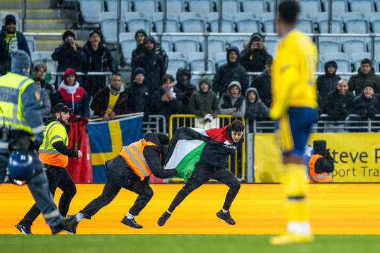 Security personell chase a pitch invader