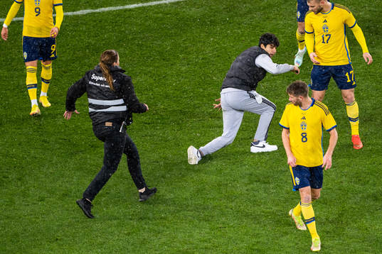 Security personel chase a pitch invader