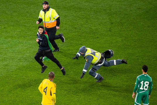 Security personel chase a pitch invader