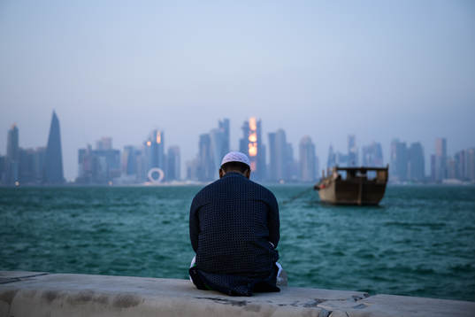 A man sits at the Corniche Promenade