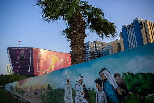 A traditional mural in front of advertising