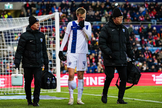 Robert Ivanov of Finland leaves the pitch with an injury