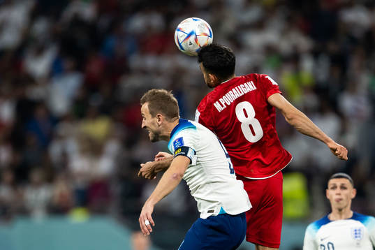 Harry Kane of England and Morteza Pouraliganji of Iran