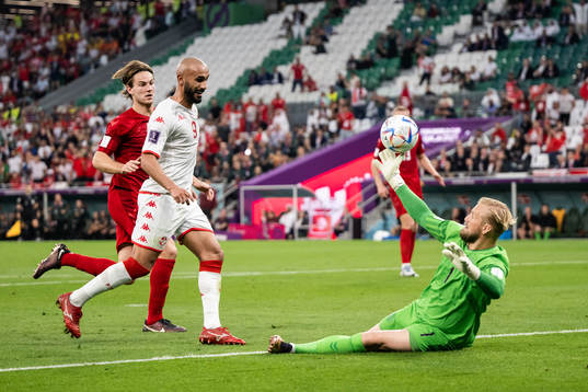 Issam Jebali of Tunisia and goalkeeper Kasper Schmeichel of