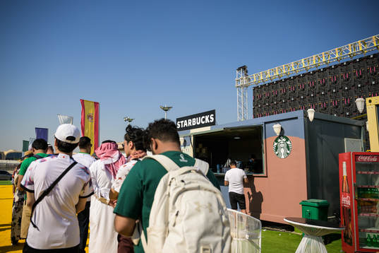 People cue to a Starbucks at Fan Village Cabins Free Zone