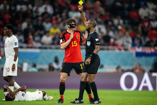 Thomas Meunier of Belgium receives a yellow card from