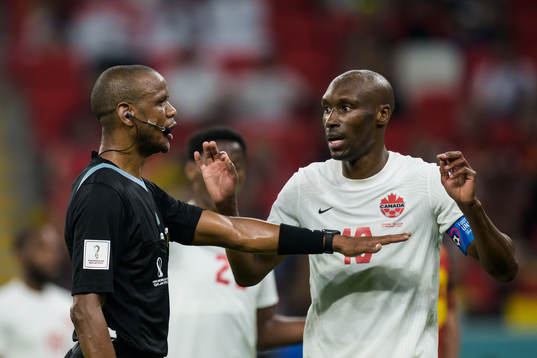 Referee Janny Sikazwe and Junior Hoilett of Canada