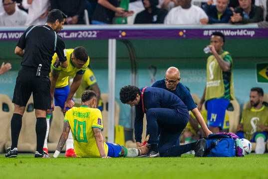 Neymar of Brazil receives medical attention