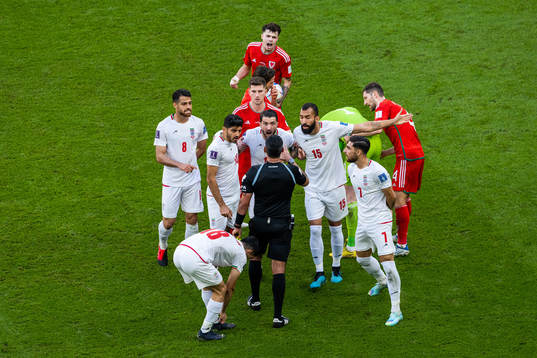 Players of Iran react toward the referee