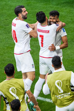 Ramin Rezaeian of Iran celebrates with Karim Ansarifard and