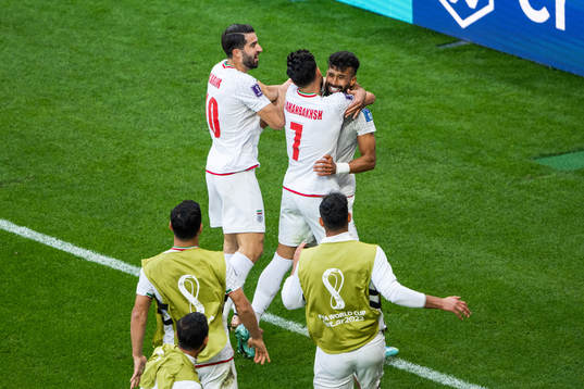 Ramin Rezaeian of Iran celebrates with Karim Ansarifard and