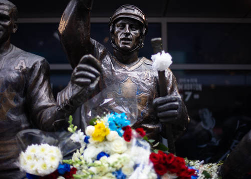 Flowers are shown in memorial at a statue of the late