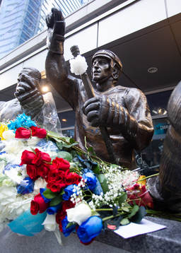Flowers are shown in memorial at a statue of the late