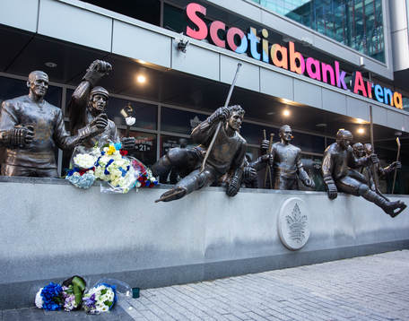 Flowers are shown in memorial at a statue of the late