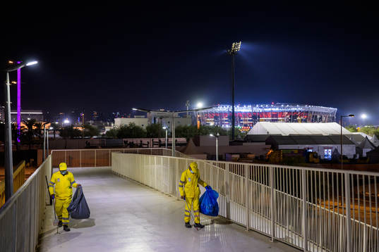 Stadium 974 is seen in the background as migrant workers