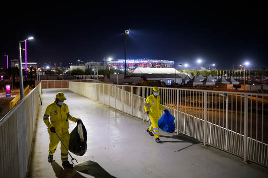 Stadium 974 is seen in the background as migrant workers