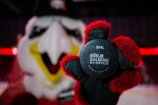 Malmö Redhawks maskot Hawkan håller fram en specialpuck