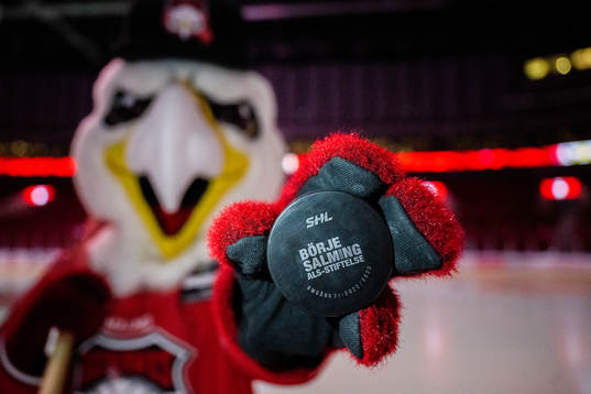 Malmö Redhawks maskot Hawkan håller fram en specialpuck
