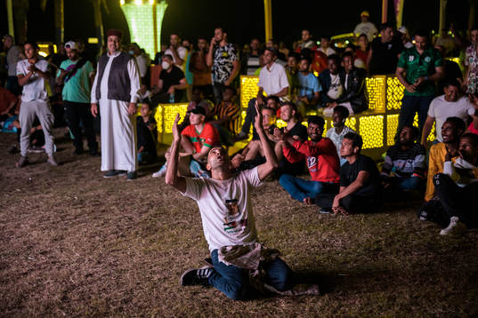 A man celebrates the 0-2 goal as he and others watch the