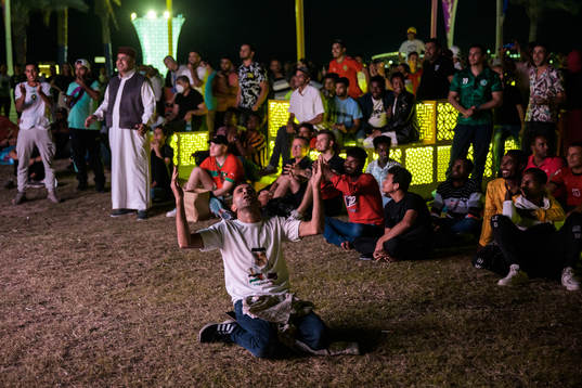 A man celebrates the 0-2 goal as he and others watch the