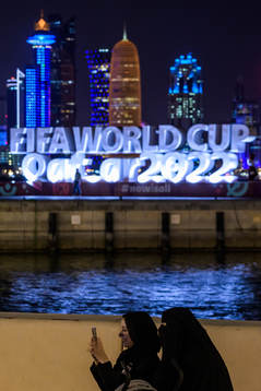 Qatari women in front of the FIFA World Cup logo