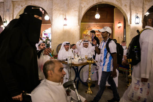 Qatari men see an Argentinian fan and Qatari woman in niqab