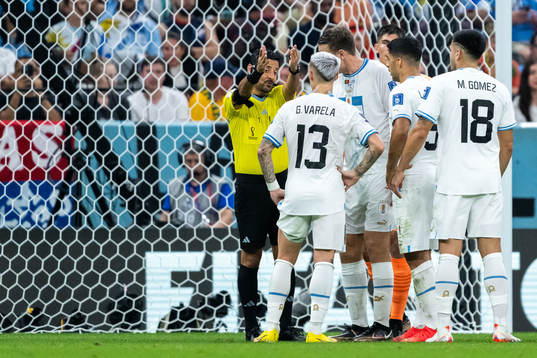 Players of Uruguay and referee Alireza Faghani