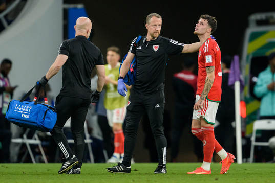 Neco Williams of Wales leaving the pitch injured