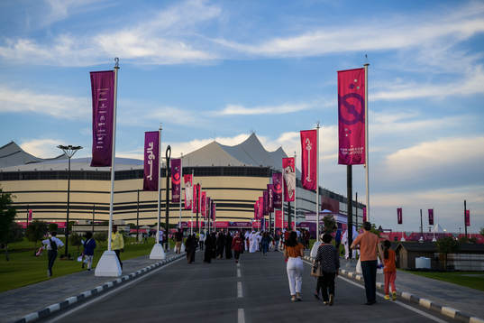 Spectators walking toward Al Bayt Stadium