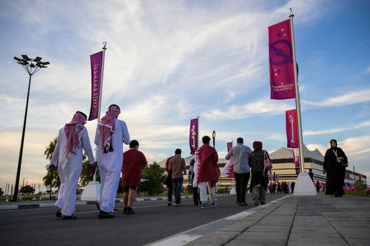 Spectators walking toward Al Bayt Stadium