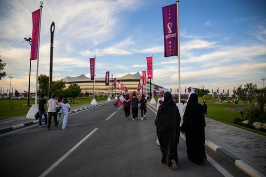 Spectators walking toward Al Bayt Stadium
