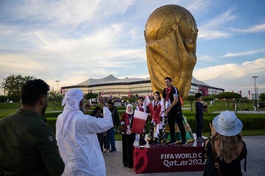 A family get their picture taken by a World Cup trophy