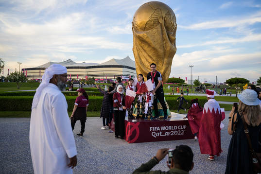A family get their picture taken by a World Cup trophy