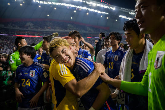 Yuto Nagatomo hugs Ritsu Doan of Japan as the team celebrate
