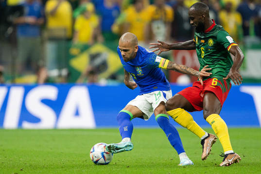 Dani Alves of Brazil and Nicolas Moumi Ngamaleu of Cameroon