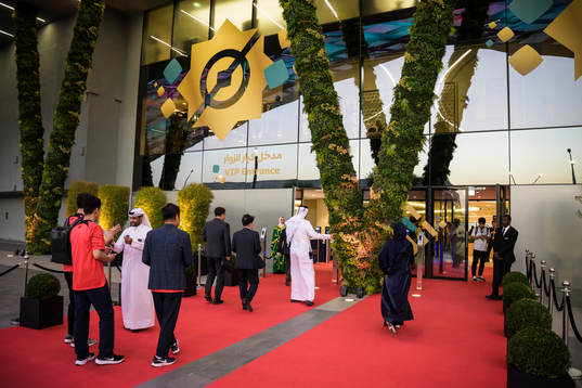 Spectators walk at a red carpet to the VIP entrance