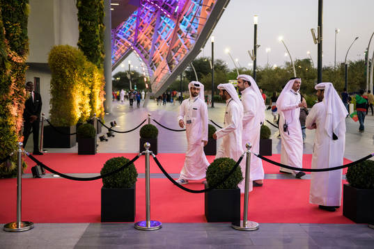 Men walk at a red carpet to the VIP entrance