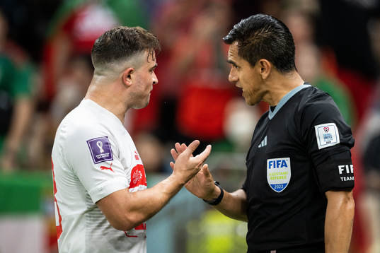 Xherdan Shaqiri of Switzerland argues with linesman