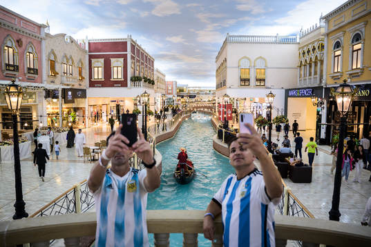 Men in Argentina jerseys take selfies as a gondola passes
