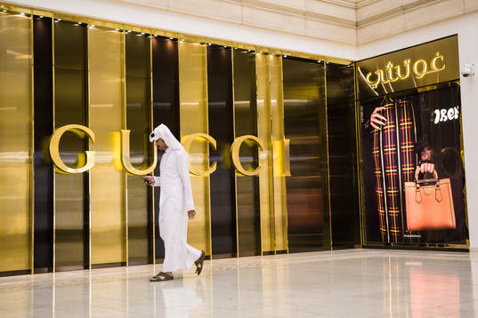 A man walks past a Gucci store at Villaggio Mall