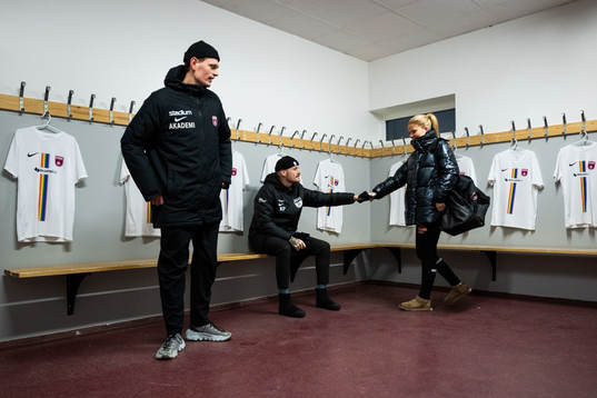 Spelare och Kristoffer Pilmalm i ett omklädningsrum med