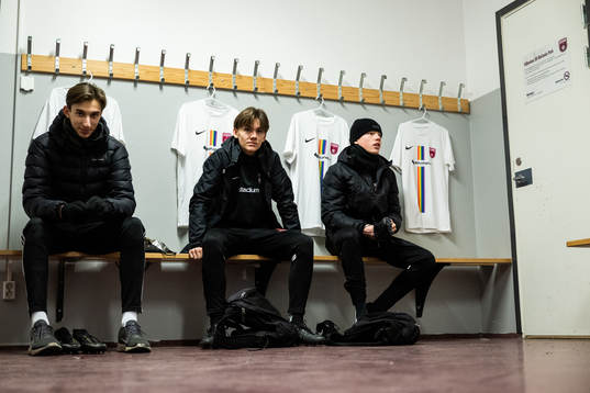 Spelare från akademin sitter i ett omklädningsrum med