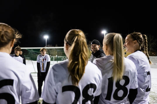 Kristoffer Pilmalm pratar med spelare från akademin