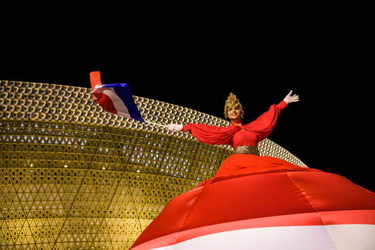 A performer waves a Dutch flag outside Lusail Stadium