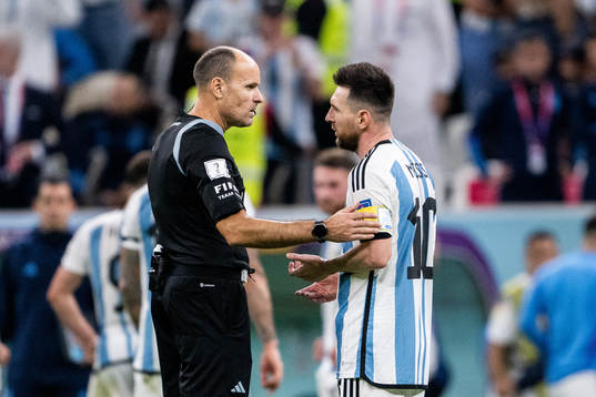 Referee Antonio Mateu Lahoz and Lionel Messi of Argentina