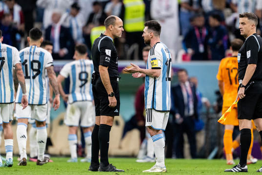 Referee Antonio Mateu Lahoz and Lionel Messi of Argentina
