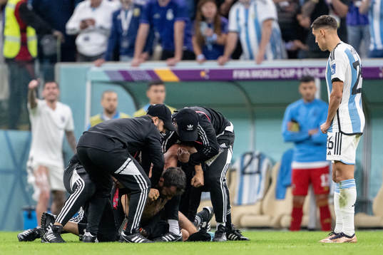 A pitch invader is detained by security